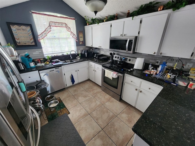 kitchen with stainless steel appliances, a textured ceiling, light tile patterned flooring, backsplash, and white cabinetry