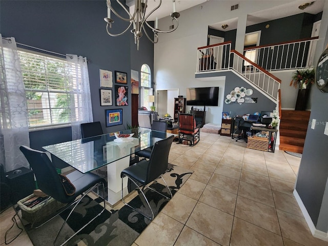 tiled dining area featuring a towering ceiling and a notable chandelier