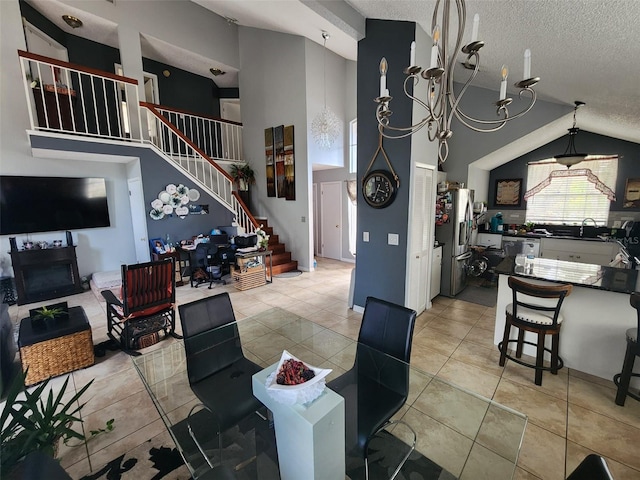 tiled dining area featuring high vaulted ceiling, a textured ceiling, and a notable chandelier