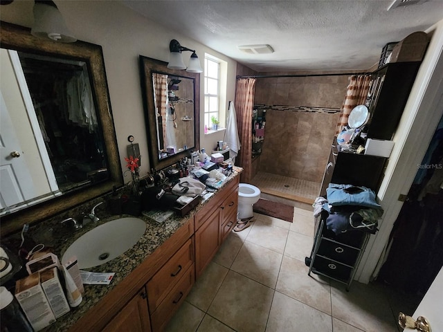 bathroom featuring vanity, a textured ceiling, tile patterned flooring, curtained shower, and toilet