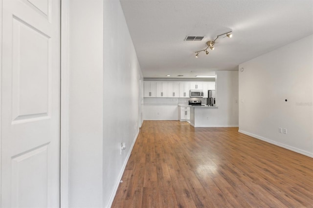 unfurnished living room featuring wood-type flooring and a textured ceiling