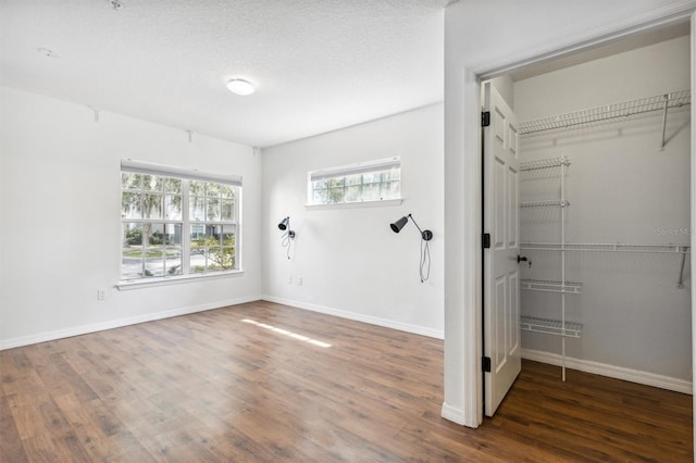 interior space with a textured ceiling, a closet, and dark wood-type flooring