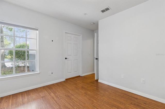 empty room featuring hardwood / wood-style floors and plenty of natural light