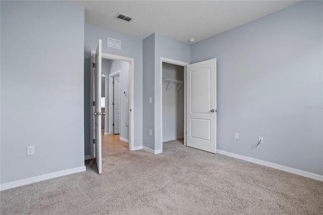 unfurnished bedroom with light carpet and a closet