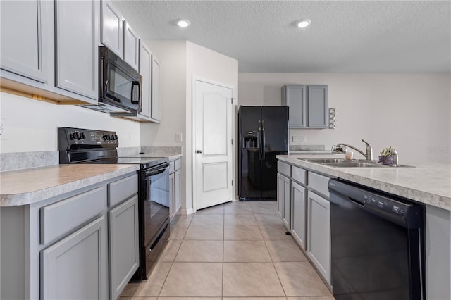 kitchen with gray cabinetry, sink, a textured ceiling, light tile patterned floors, and black appliances