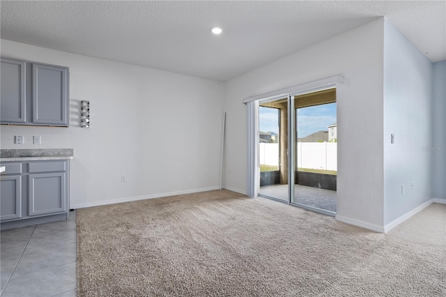 interior space featuring light carpet and a textured ceiling