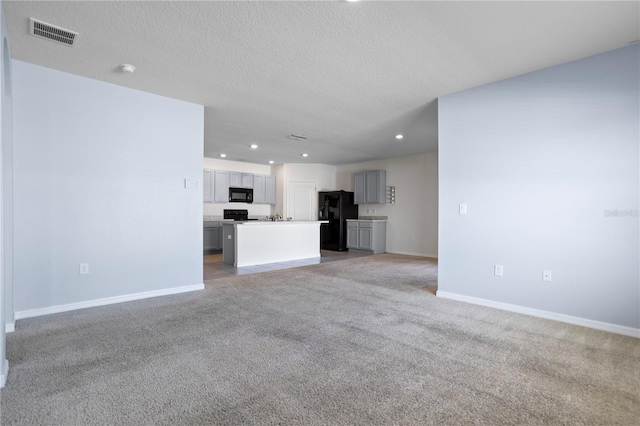 unfurnished living room with carpet flooring and a textured ceiling