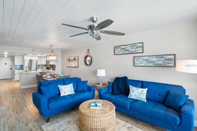 living room featuring ceiling fan with notable chandelier, wood ceiling, and light hardwood / wood-style flooring