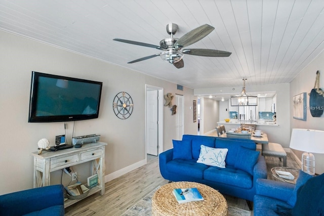 living room featuring ceiling fan with notable chandelier, light hardwood / wood-style floors, and wood ceiling