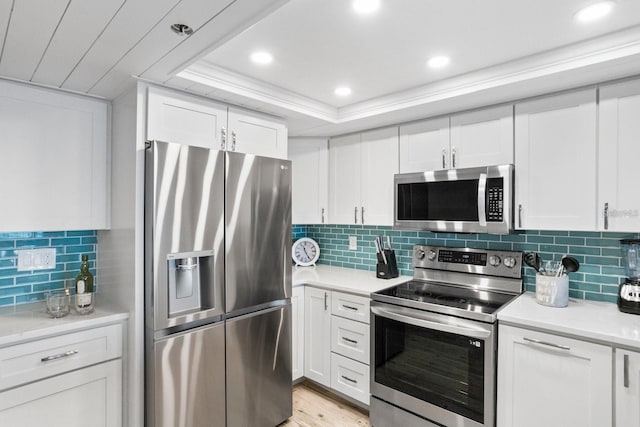 kitchen featuring light hardwood / wood-style flooring, white cabinetry, decorative backsplash, and stainless steel appliances