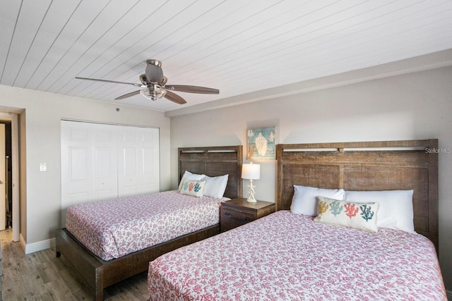 bedroom featuring a closet, wood ceiling, wood-type flooring, and ceiling fan