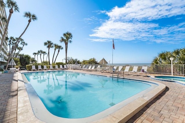 view of swimming pool featuring a water view and a patio area