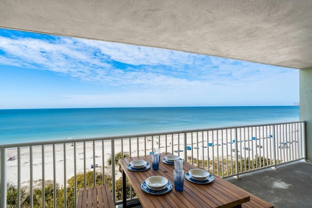 balcony featuring a beach view and a water view