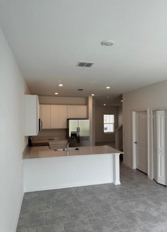 kitchen with stainless steel appliances, white cabinets, and kitchen peninsula