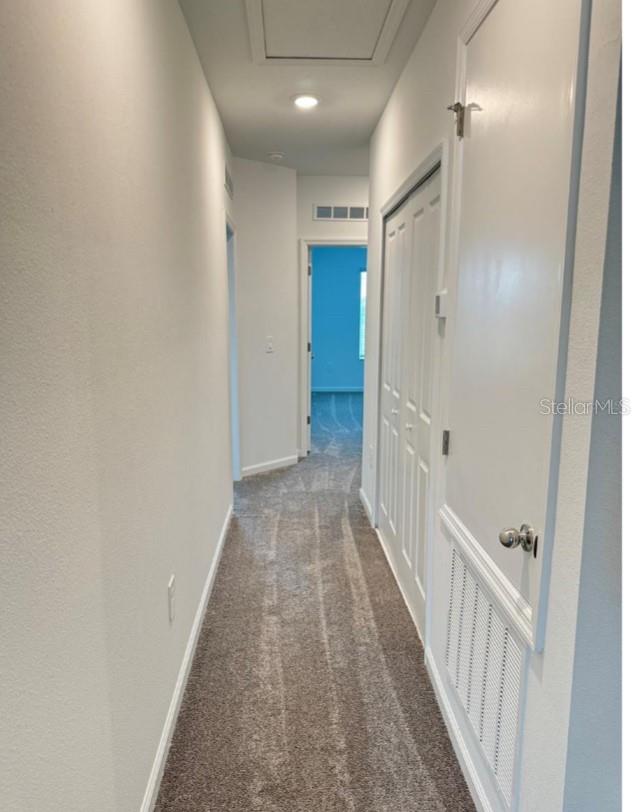 hallway with dark colored carpet