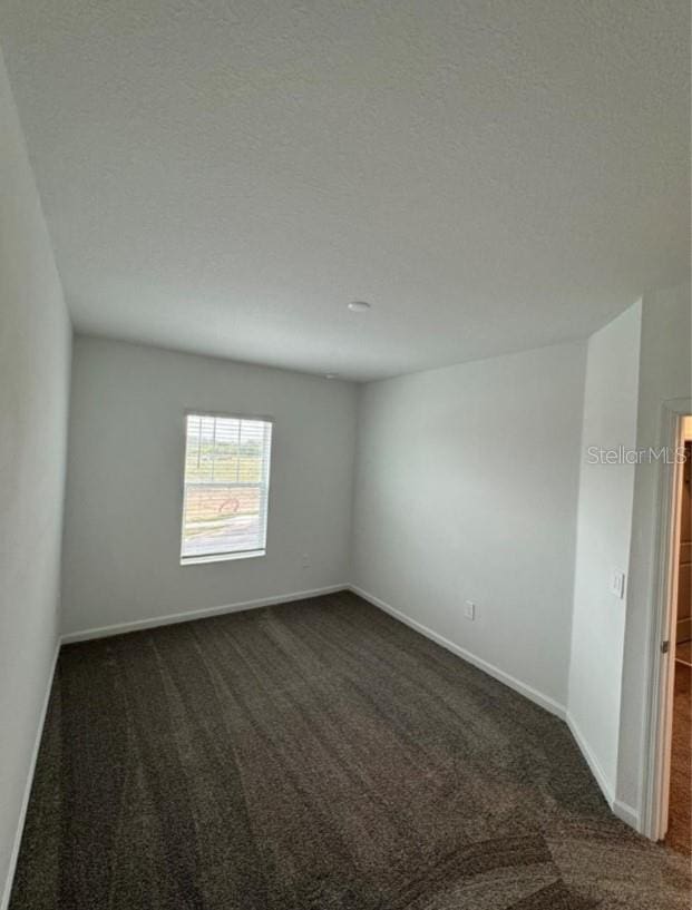 carpeted empty room with a textured ceiling