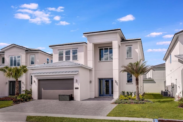 view of front of home featuring a front lawn, a garage, and french doors