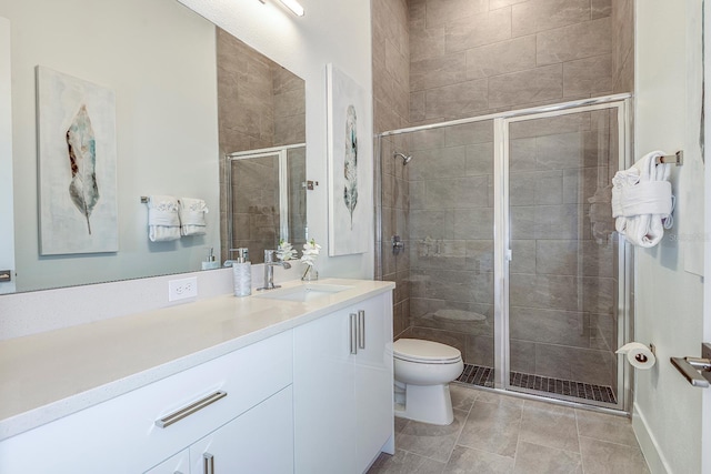 bathroom with vanity, toilet, and a shower with door