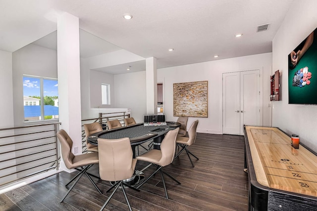 dining room featuring a textured ceiling, a water view, and dark hardwood / wood-style floors