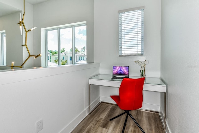 home office featuring hardwood / wood-style floors, plenty of natural light, and built in desk