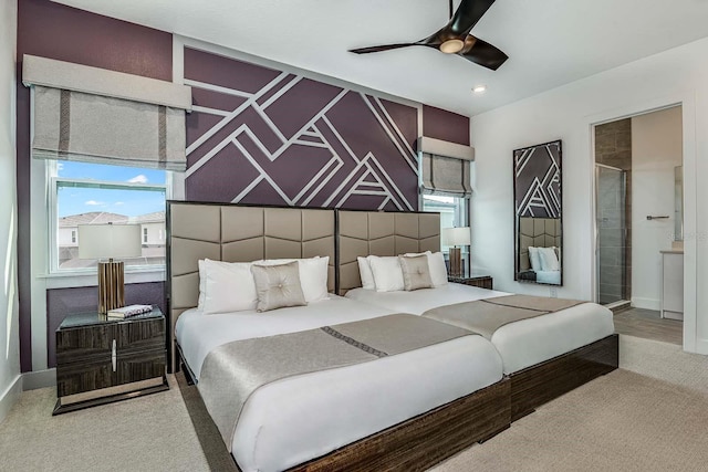 carpeted bedroom with ensuite bath and ceiling fan