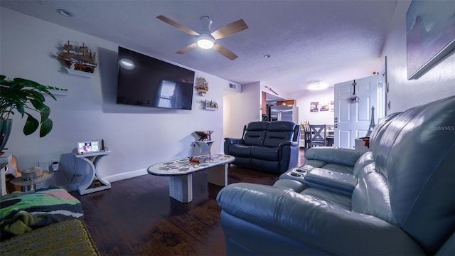 living room with dark wood-type flooring, a textured ceiling, and ceiling fan