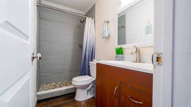 bathroom featuring ornamental molding, vanity, a textured ceiling, hardwood / wood-style flooring, and toilet