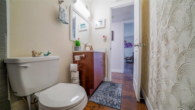 bathroom featuring toilet, vanity, and wood-type flooring