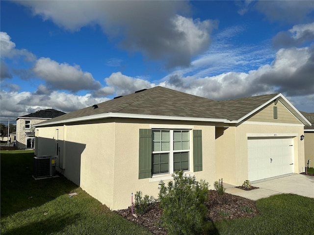 view of home's exterior featuring a garage, a lawn, and central AC