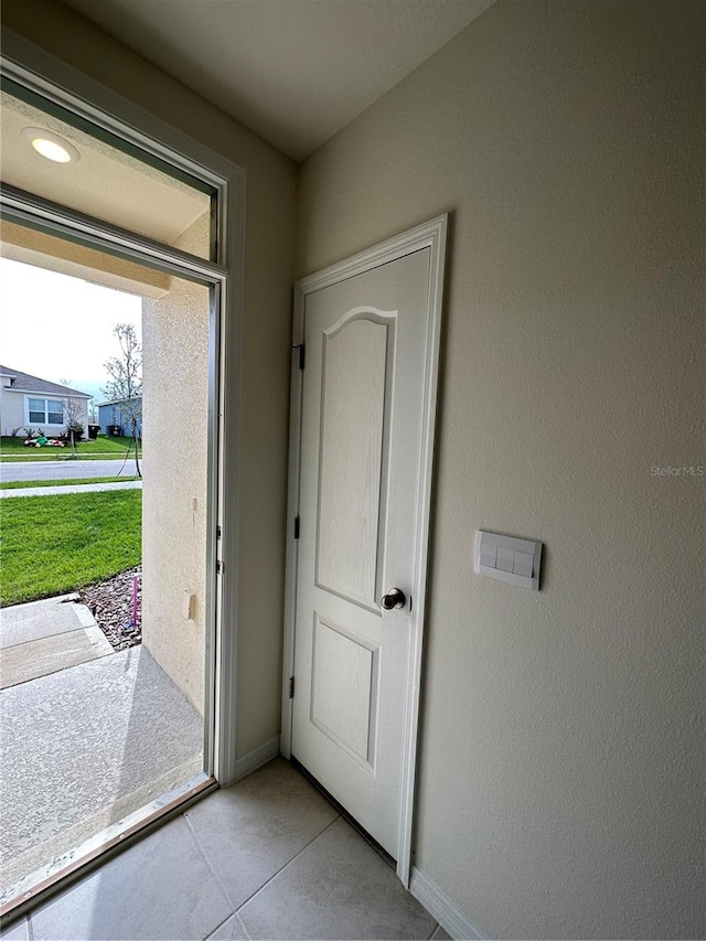 doorway with light tile patterned flooring