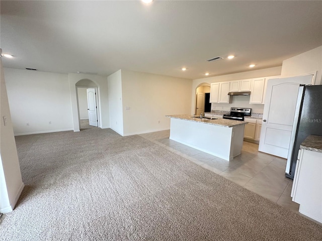 kitchen with stainless steel range with electric cooktop, fridge, white cabinets, light colored carpet, and a kitchen island with sink