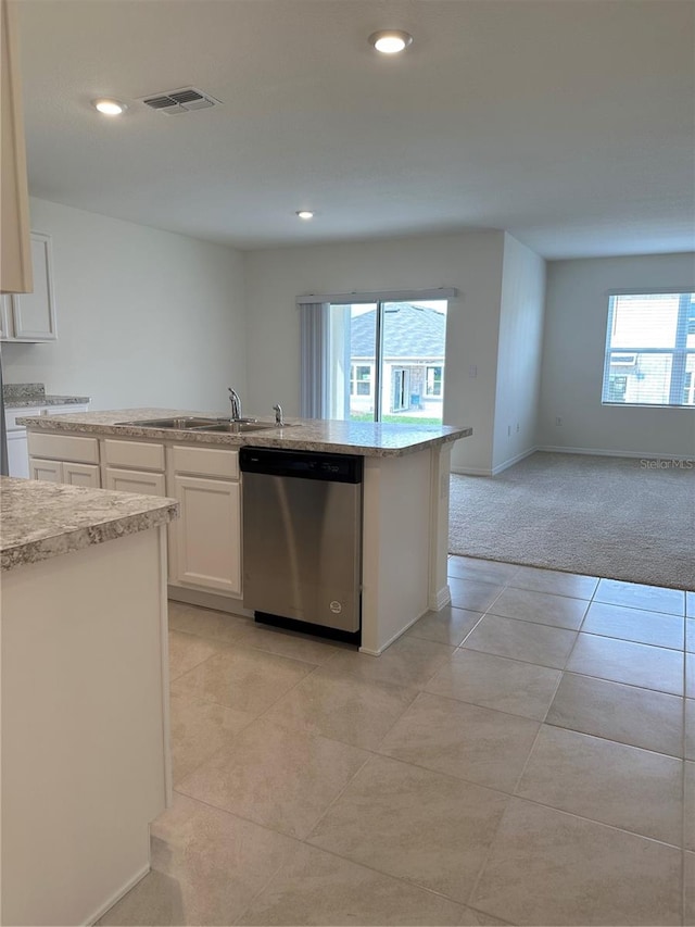 kitchen featuring sink, white cabinets, stainless steel dishwasher, light colored carpet, and a kitchen island with sink