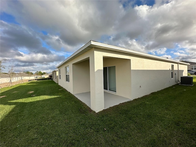 view of side of property with central air condition unit, a yard, and a patio area