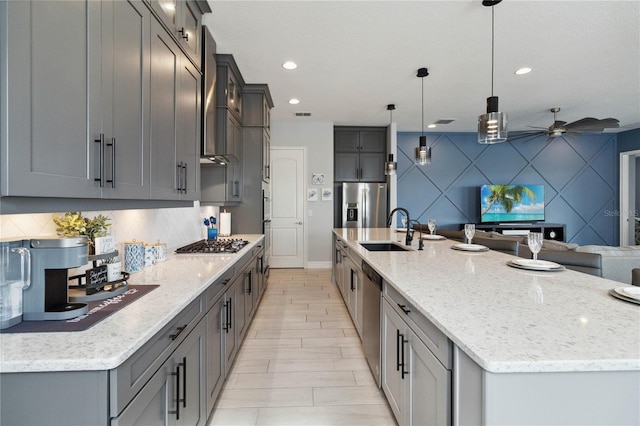 kitchen with sink, tasteful backsplash, a large island, pendant lighting, and appliances with stainless steel finishes