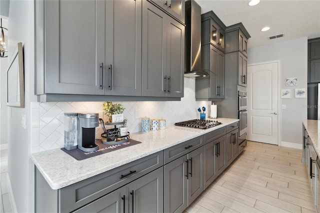 5075 Twin Lakes Blvd, Saint Cloud, FL 34772 - kitchen featuring wall chimney exhaust hood, tasteful backsplash, gray cabinets, light stone countertops, and glass insert cabinets