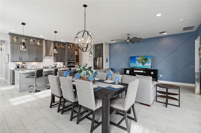 dining area featuring ceiling fan with notable chandelier