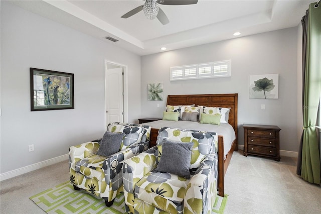 bedroom featuring light carpet, ceiling fan, and a raised ceiling