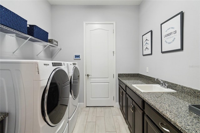 washroom featuring sink, washer and dryer, and light hardwood / wood-style flooring