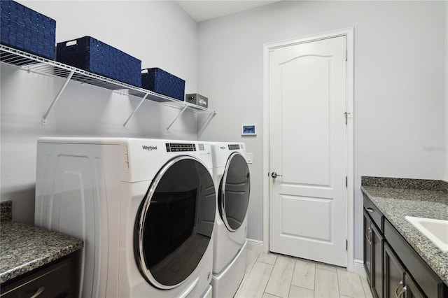 clothes washing area with independent washer and dryer and light hardwood / wood-style flooring