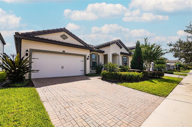 7845 Wandering Way, Orlando, FL 32836 - view of front of home featuring decorative driveway, a garage, stucco siding, and a front yard