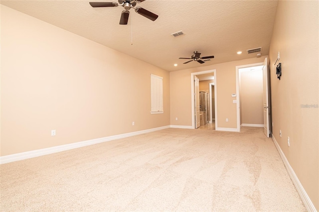 carpeted spare room featuring a textured ceiling and ceiling fan