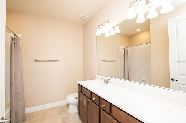 bathroom with toilet, vanity, and tile patterned flooring