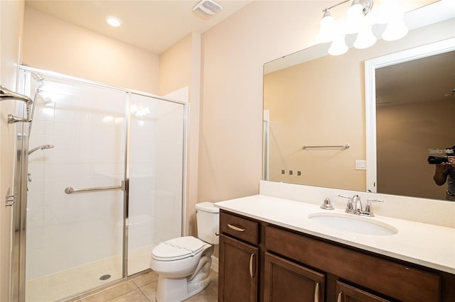 bathroom with toilet, vanity, tile patterned floors, and a shower with shower door