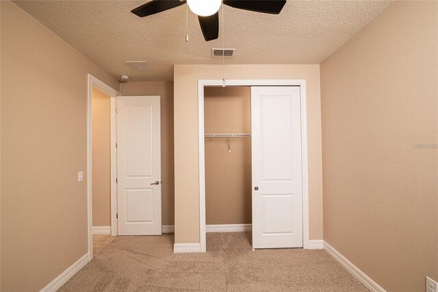 7845 Wandering Way, Orlando, FL 32836 - unfurnished bedroom with light colored carpet, a textured ceiling, a closet, baseboards, and ceiling fan