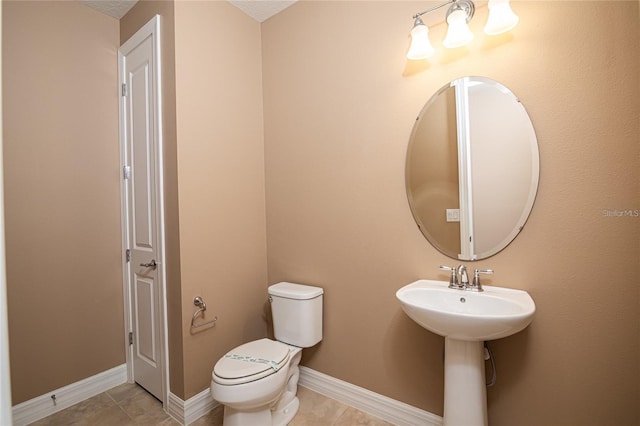 7845 Wandering Way, Orlando, FL 32836 - half bathroom featuring toilet, a sink, tile patterned flooring, and baseboards