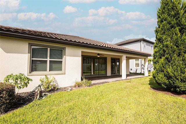 back of property featuring a patio area, a yard, and ceiling fan