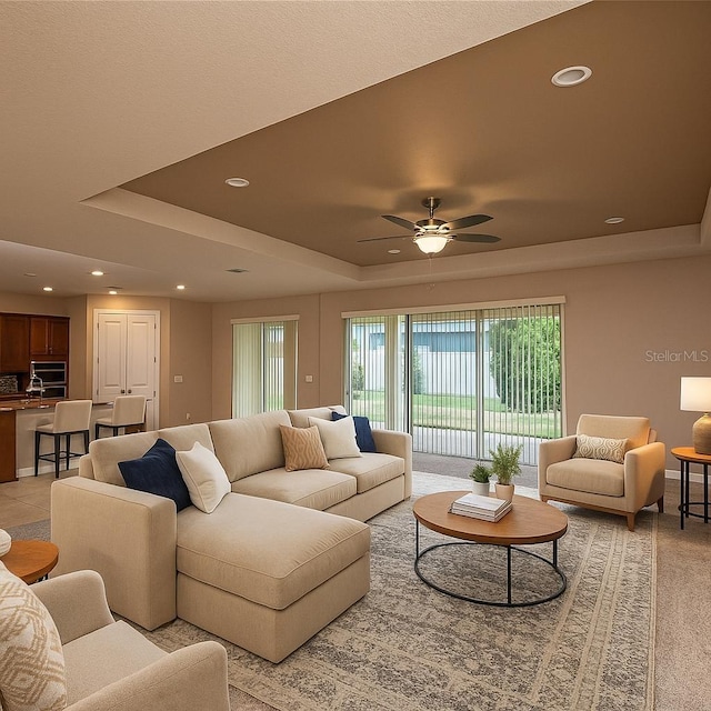 7845 Wandering Way, Orlando, FL 32836 - living area with a raised ceiling, a ceiling fan, recessed lighting, and light colored carpet