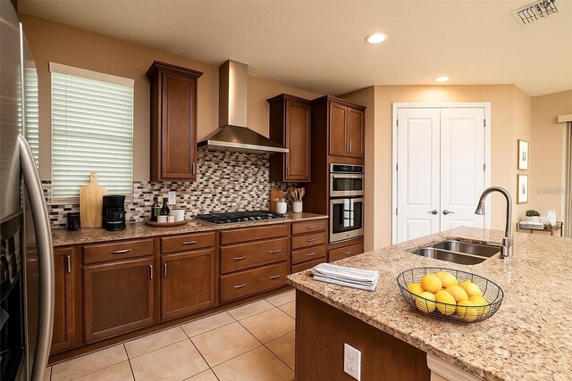 7845 Wandering Way, Orlando, FL 32836 - kitchen featuring a sink, wall chimney range hood, appliances with stainless steel finishes, light stone countertops, and light tile patterned floors