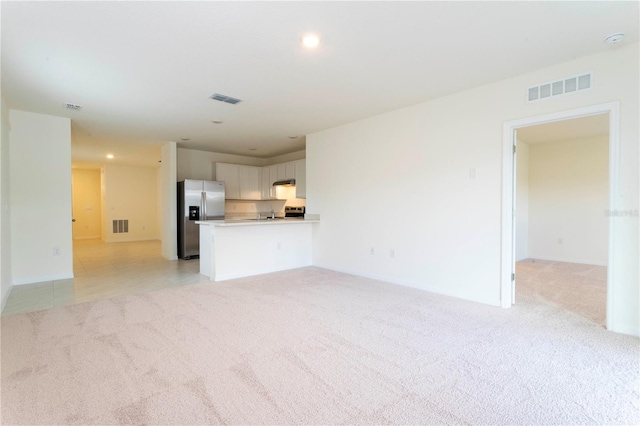 unfurnished living room featuring light carpet