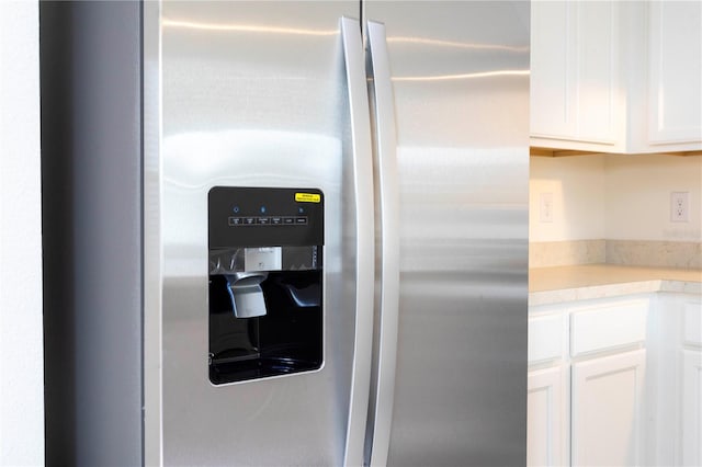 interior details with white cabinetry and stainless steel refrigerator with ice dispenser